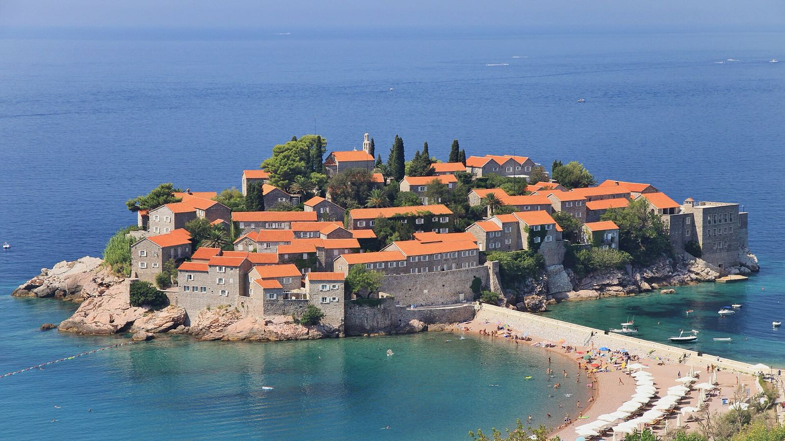Sveti Stefan islet, packed with stone houses and orange roofs, joined to the coast by its causeway